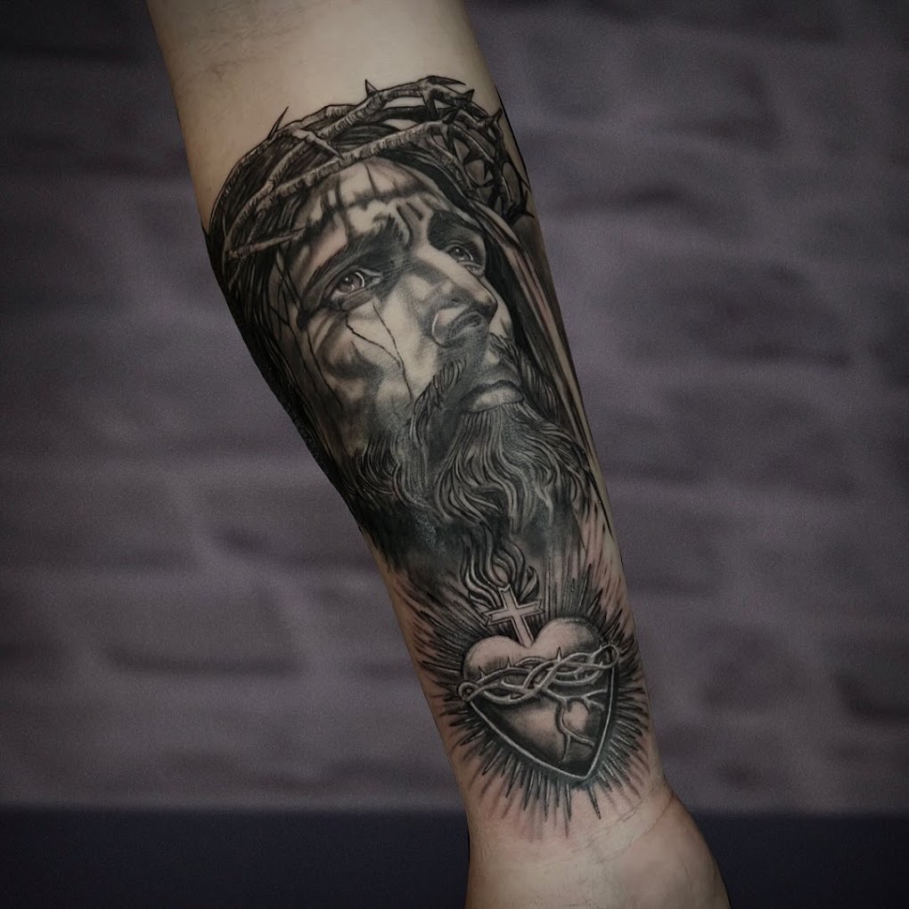 Tatouage réaliste, portrait du Christ et cœur sacré sur avant-bras
